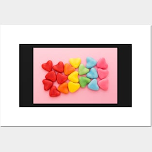 Heart-shaped multi-colored candy ordered in rainbow colors and shape on a pink background Posters and Art